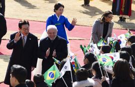 El presidente de Brasil Luiz Inacio Lula da Silva (centro, der) es recibido en Seúl por el mandatario surcoreano Lee Jae Myung (i).