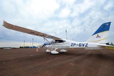 Avión ZP-BVZ de colores blanco y azul, estacionado en pista de aterrizaje, sin personas visibles, con cielo nublado de fondo.