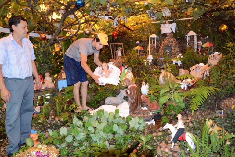 Esteban Sabaté y su hijo, colocando la imagen del Niño Jesús en el 2014.