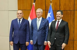 Núñez y Latorre sonríen en trajes formales, rodeados de banderas en un contexto oficial con Kast en el centro.