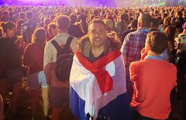 Envuelto en una bandera paraguaya, el embajador del Reino Unido en paraguay, Ramin Navai, entre el público asistente al festival de Glastonbury, en Somerset, Inglaterra.
