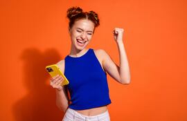 Mujer con el celular en la mano.