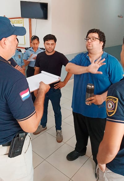 Iván Ismael Insfrán Torres cuenta a un policía como ocurrió el asalto. A l lado, su chofer Andrés Benítez Galeano escucha el relato.