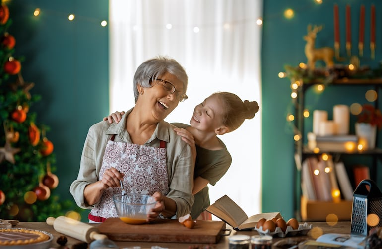 Abuela y su nieta comparten un tiempo juntas mientras preparan postres para la Navidad.