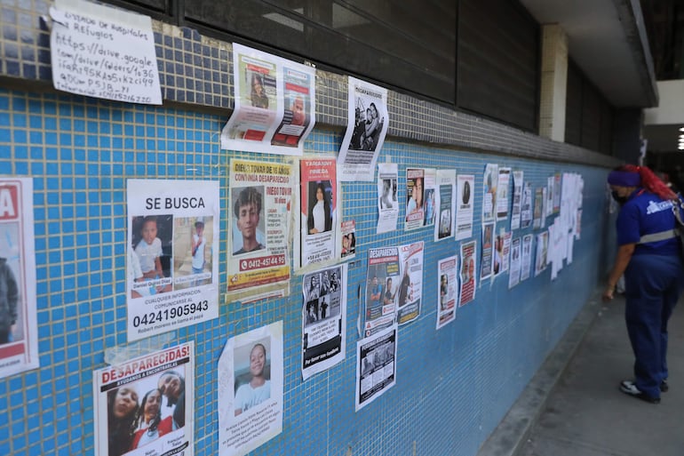 Una mujer observa carteles este lunes, de personas desaparecidas en el Hospital Pérez Carreño en Caracas (Venezuela).