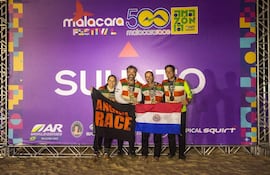 Cuatro miembros del equipo Angiru sonríen, vistiendo camisetas coloridas, sosteniendo banderas paraguaya y negra tras una competencia deportiva.