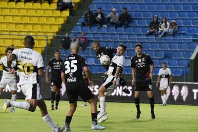 El delantero de Olimpia Carlos Sebastián Ferreira disputa el duelo aéreo con el zaguero Jorge González Vázquez. Arístides Vera (35) y Gaspar Vega observan la acción.