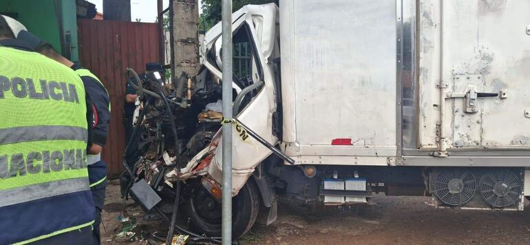Tres policías en uniforme de alta visibilidad revisan un camión destrozado en una escena exterior. El ambiente es urbano.