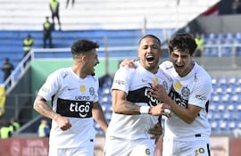 El capitán de Olimpia, Richard Ortiz celebra el tanto de apertura del marcador ante Sportivo Luqueño, en medio de Fernando Cardozo y Eduardo Delmás.