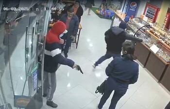 El circuito cerrado captó el momento en que los  "motochorros" irrumpieron en el local de empanadas "Kily" en Lambaré, encapuchados y con armas de fuego en mano.