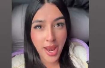 Shirley Boom con expresión crítica en su smartphone, publicando un mensaje sobre la defensa de derechos en redes sociales.