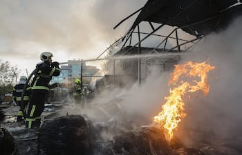 Bomberos trabajan este martes en el sitio de un bombardeo ruso en Kiev.