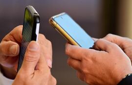 Personas revisando sus teléfonos celulares.