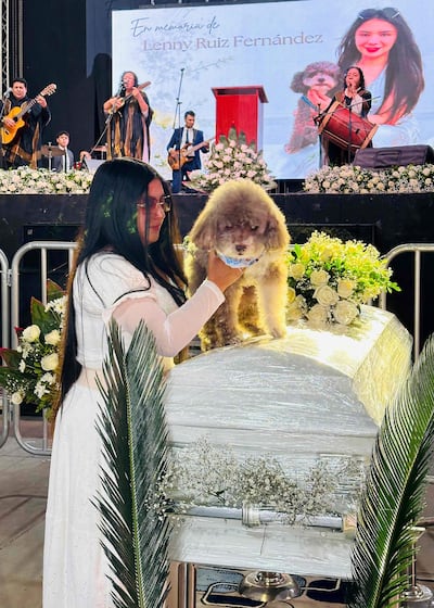 Jessica Flórez, cuñada del abogado colombiano Lenny Ruiz, quien murió al proteger a su perro Salomón durante el terremoto del 10 de agosto en Cali, sostiene a Salomón durante el funeral de Ruiz, en Pasto, Colombia, el 13 de agosto de 2026.