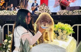 Jessica Flórez, cuñada del abogado colombiano Lenny Ruiz, quien murió al proteger a su perro Salomón durante el terremoto del 10 de agosto en Cali, sostiene a Salomón durante el funeral de Ruiz, en Pasto, Colombia, el 13 de agosto de 2026.
