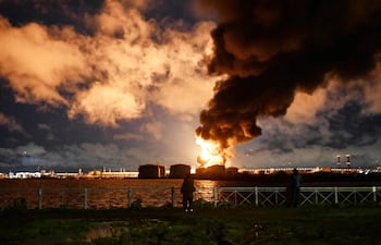 Varias personas observan una terminal petrolera en llamas tras un ataque aéreo en San Petersburgo el 18 de octubre de 2026, en el contexto del conflicto ruso-ucraniano en curso.