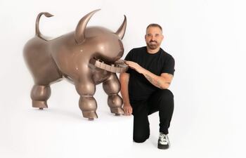 Sebastián Boesmi posa con su gran escultura del "Piano Bull", que se está exhibiendo en Asunción.