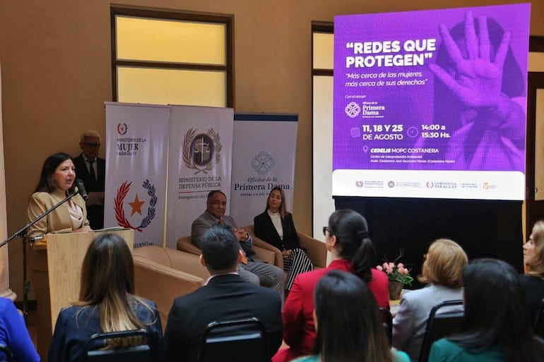 Alicia Pomata en atril, mientras Javier Esquivel y Antonella Albertini la escuchan atentamente en un evento del Ministerio de la Mujer.