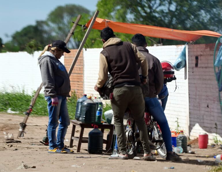 Los clientes se acercan a comprar combustible de contrabando, arriesgando sus vidas por ahorrar un par de guaraníes.