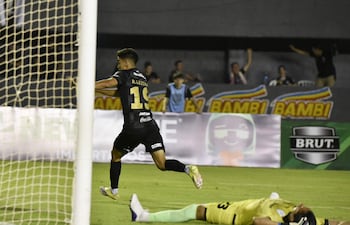 El talentoso volante ofensivo Rubén Lezcano celebra el tanto ganador ante el lamento del portero Miguel Martínez, quien expresa su frustración quedando tendido en el césped.