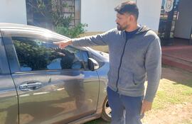 Fabio Chávez, mostrando el orificio de entrada del proyectil que impactó en la ventanilla derecha de su rodado.