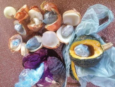 Elementos naturales como cebollas y calabaza sobre una superficie marrón, sin personas presentes.