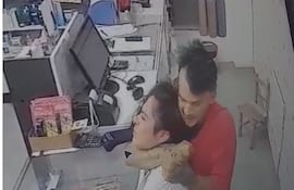 Jeisson Fernando Bogado Acuña, sujeta del cuello a la empleada Tamara Jazmín Leite Agüero, quien se negó a entregar el dinero que había en la caja.