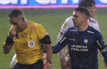 el árbitro Héctor Jona se toca nariz luego del altercado al lado el uruguayo Kevin Altez tratando de pedir disculpas.