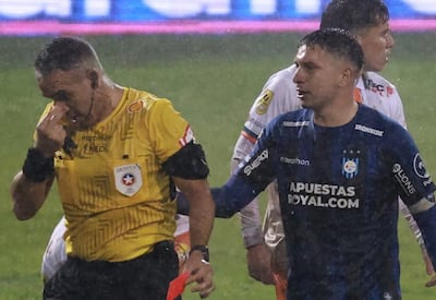 el árbitro Héctor Jona se toca nariz luego del altercado al lado el uruguayo Kevin Altez tratando de pedir disculpas.