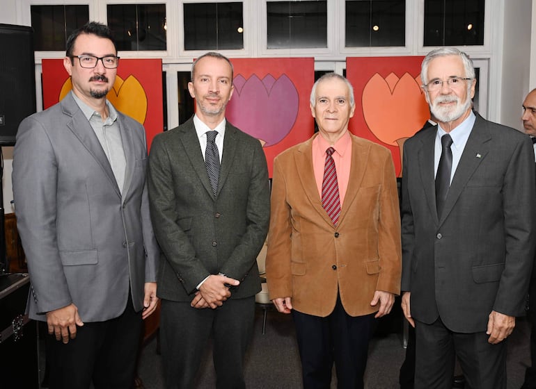 NANIEL NASTA con chaqueta gris claro, Juan Manuel Nungaray en saco verde oscuro y Javier Parrondo en saco marrón claro, todos en un ambiente elegante.