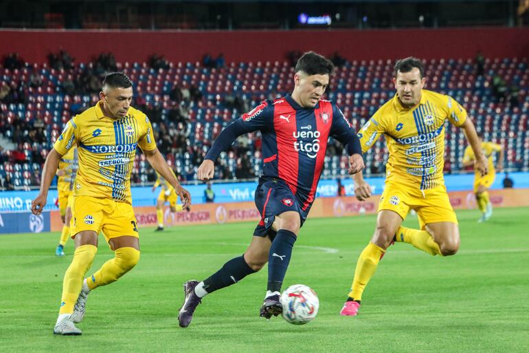 El delantero de Cerro Porteño, Ignacio Aliseda transporta el esférico ante las marcas del extremo Joel Román y el experimentado, Néstor Camacho.