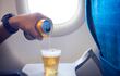 Un hombre vierte cerveza en un vaso, en pleno vuelo.