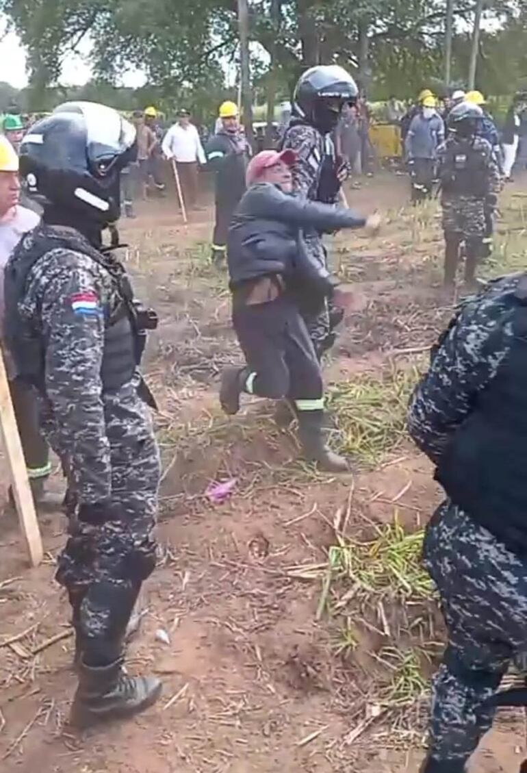 Un empleado de La Felsina arroja un proyectil hacia los presuntos invasores. Intervinieron efectivos policiales para evitar una situación de mayor gravedad.