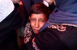 Un niño palestino llora después de un ataque israelí que destruyó la escuela Rafida, que albergaba a personas desplazadas en Deir al-Balah, Franja de Gaza, 10 de octubre de 2024 (AFP).