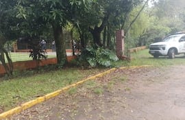 Camioneta de policía con logos de ITAIPU en un área natural, con miembros de seguridad en uniforme oscuro tras una cerca.