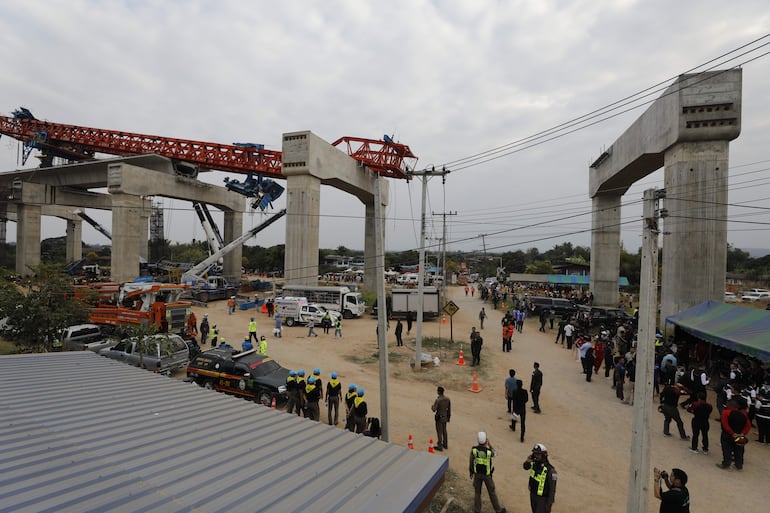 Rescatistas trabajan en los restos de un tren de pasajeros tras el desplome de una grúa de construcción sobre él en el distrito de Sikhio, Nakhon Ratchasima, Tailandia, el 14 de enero de 2026. 