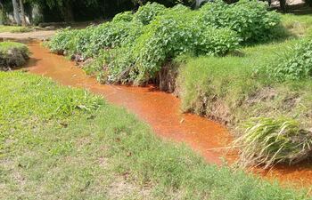 Situación anómala de un arroyo que va por la calle Gómez Serrato y esquina Tte. Alfredo Placita (barrio Mburucuyá) que se encuentra teñido de naranja.