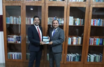 Jorge Bogarín Alfonso entregó un libro de su coautoría a Gerardo Bobadilla.