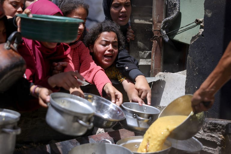 Varias personas desplazadas intentan conseguir comida en un centro de distribución de ayuda humanitaria en Yabalia, en el norte de la Franja de Gaza.