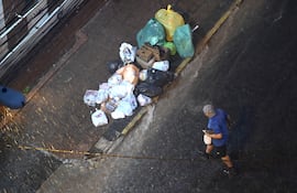 Bolsas de residuos acumuladas en una esquina del microcentro de Asunción, durante una intensa lluvia.