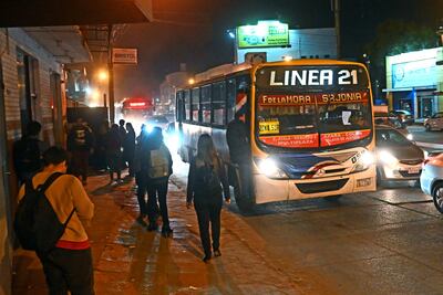 Gente esperando ómnibus en horas de la madruga afectados con el cambio de horario de verano.