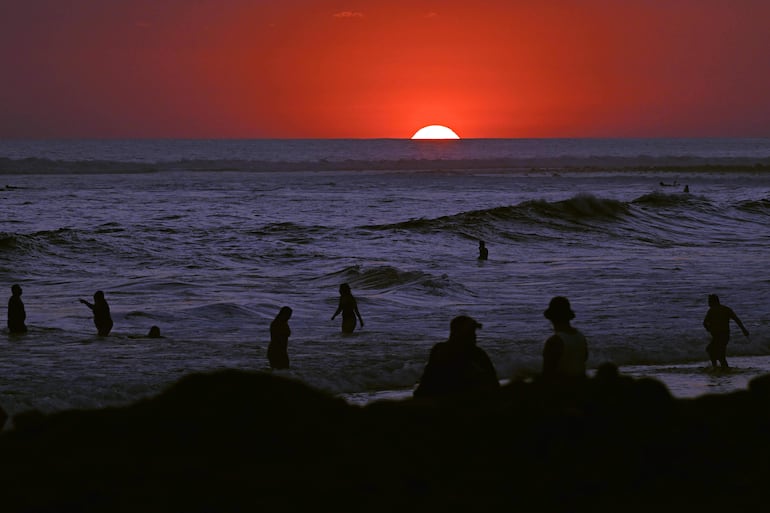 Turistas disfrutan del atardecer en la playa El Tunco, en La Libertad, El Salvador, el 13 de febrero de 2026.