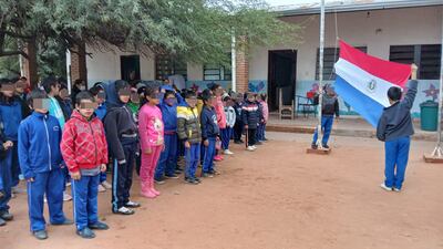 Niños de la humilde Escuela Nueva Asunción, que no tiene aulas suficientes en Villa Hayes, entonan el himno nacional. 