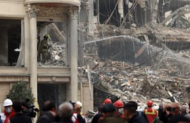 Un grupo de rescatistas trabaja entre los escombros de un edificio que fue atacado por Estados Unidos e Israel esta mañana en el barrio de Andarzgu, en el noreste de Teherán.