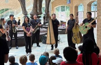 Favio Chávez y otros músicos, vestidos de negro, tocan instrumentos reciclados frente a un público infantil en el museo.