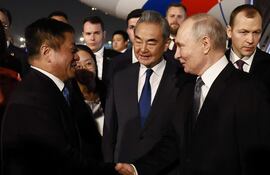 El presidente ruso Vladimir Putin (C-D) es escoltado por el ministro de Asuntos Exteriores de China, Wang Yi (C), a su llegada a Pekín, China.