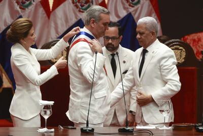 Luis Abinader (c) recibe del presidente del Senado, Ricardo de los Santos (d), la banda de presidencial en su investidura como presidente de República Dominicana hoy, junto a la vicepresidenta Raquel Peña en el Teatro Nacional en Santo Domingo (República Dominicana). Abinader asumió este un segundo y último mandato de cuatro años en presencia de más de una decena de jefes de Estado y de Gobierno, entre ellos el rey de España, tras haber ganado ampliamente la reelección en los comicios del 19 de mayo pasado.