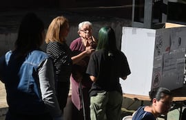 Adulta mayor siendo asistida para ejercer su voto.