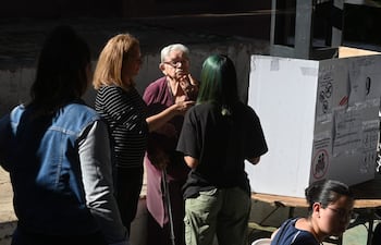 Adulta mayor siendo asistida para ejercer su voto.