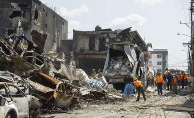 Organismos de emergencias trabajan en la zona donde ocurrió una enorme explosión y posterior incendio, registrados el lunes, en el centro de San Cristóbal (República Dominicana).